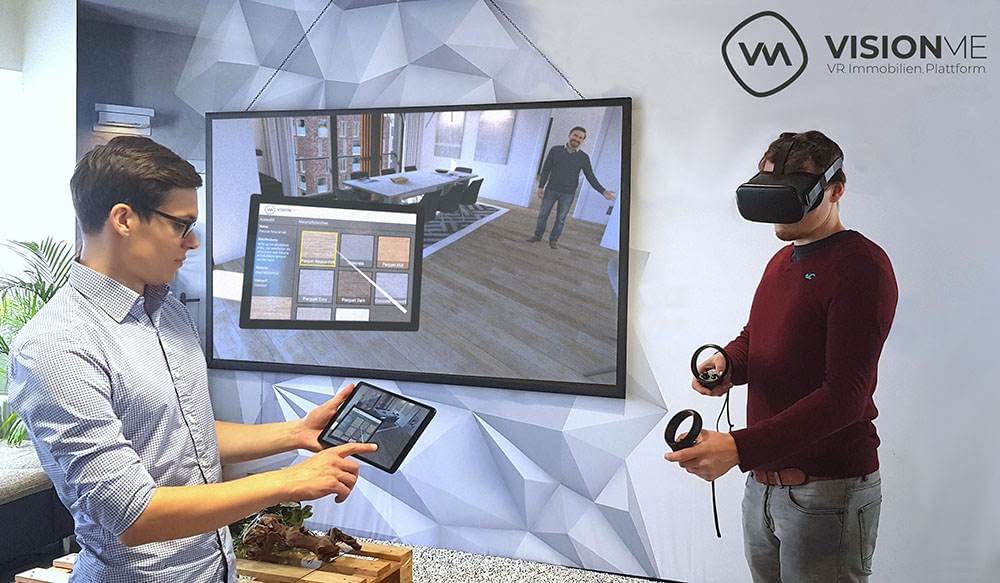 VR-Beratung_inkl_Mensch Visionme Geschäftsführer Florian Wenk und Dennis Dohmeier präsentieren den Immobilien Designer auf VR-Brille und Tablet mit Beamer im Hintergrund